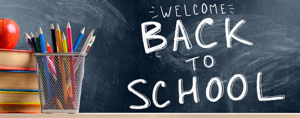 school supplies sitting front of chalkboard that says 'Welcome back to school'